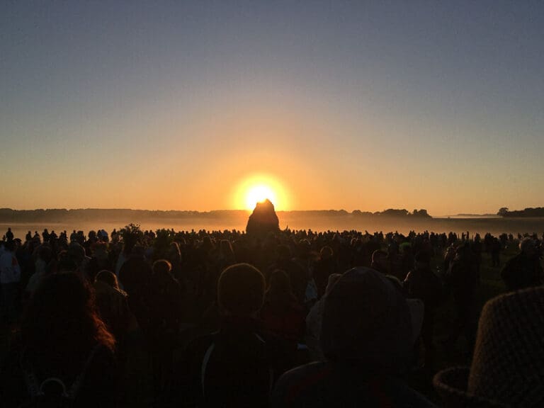 Stonehenge Summer Solstice, the sun showing above the Heel Stone. The prehistoric monument in England.