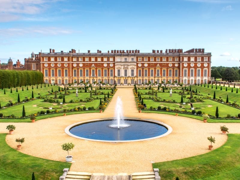 The walkway to Hampton Court Palace surrounded by the large garden. Half-Day Trip from London with Entry Tickets.