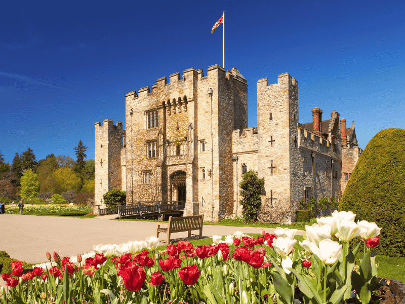Hever Castle surrounded by its moat and gardens on a sunny day in Kent, visited on the Anderson Tours Leeds and Hever Castle Day Tour from London.