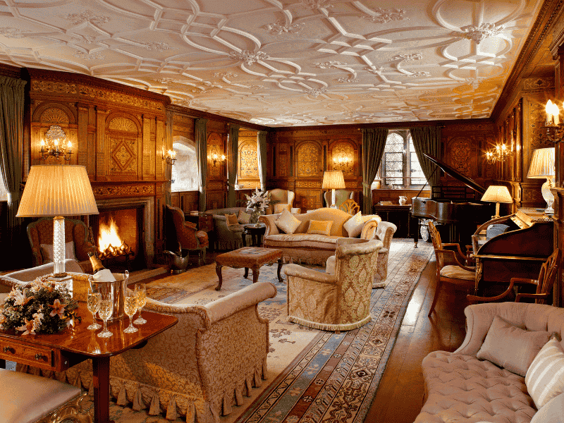 The Drawing Room at Hever Castle with ornate ceilings, warm lighting, and period furnishings — featured on the Anderson Tours Leeds and Hever Castle Day Tour from London.